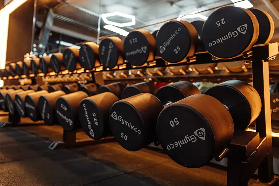 Rows of rubber dumbbells on a rack at UnReal Gym