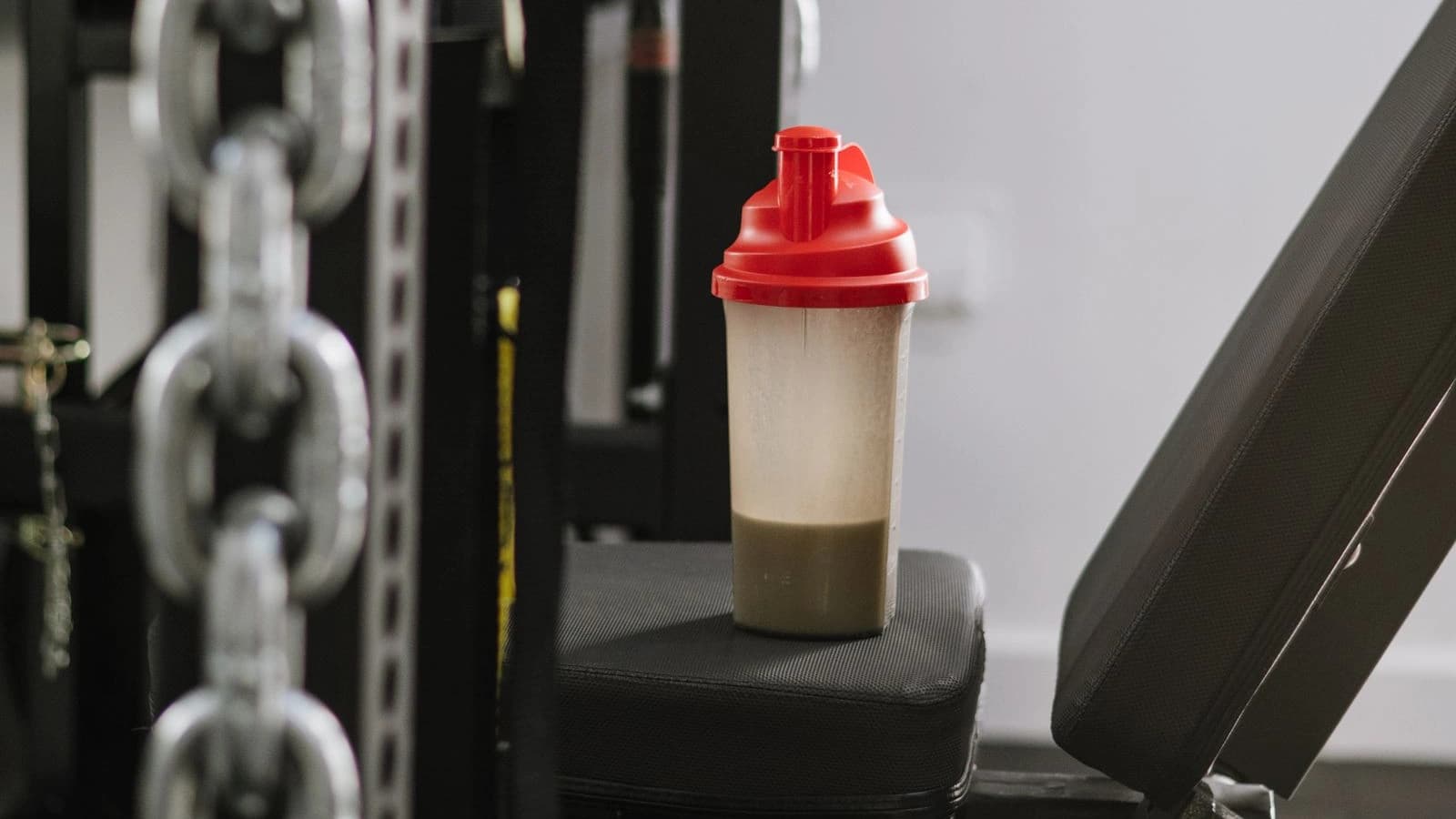 A protein shaker resting on gym equipment after training